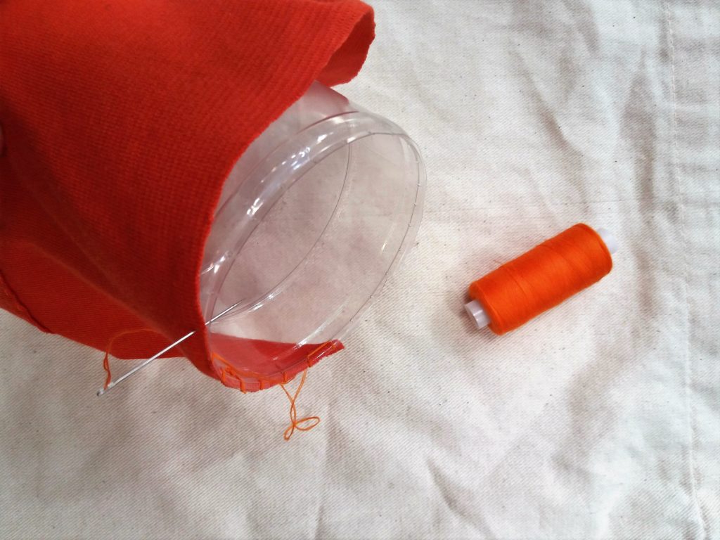 Dłuższy brzeg tkaniny bez zakładki szyty do brzegu butelki